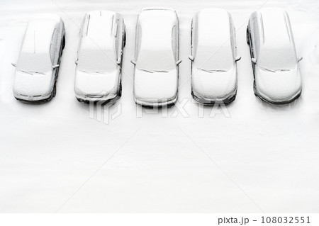 Cover winter parking lot cars under snow covered cars winter season. Snowy row of cars snow background winter time. Top view. Cold weather. Snowbound, Snow weather conditions. Above view. White design 108032551