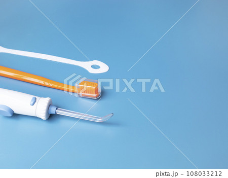 Toothbrush, Oral Irrigator, Floss, Tongue Scraper On Blue Background. Dental Cleaning Set, Oral Hygiene. Flat Lay Of Dental Care Tools, Tooth Hygienic Equipment. Horizontal Plane. Copy Space For Text. 108033212