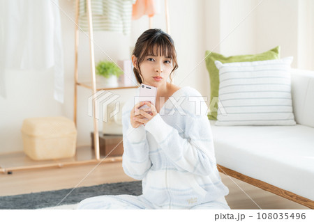 リビングでスマホを見る若い女性 リビングでスマホを見る若い女性 108035496