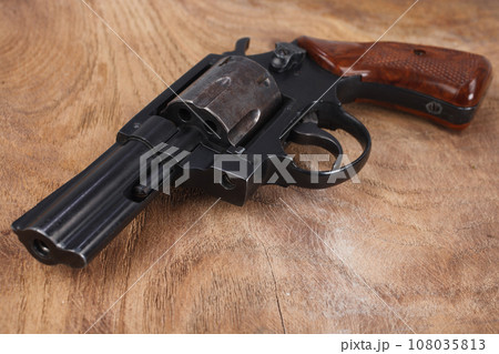 Revolver on wooden table Revolver on wooden table 108035813