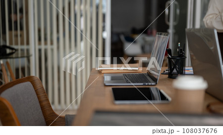 Side view image of a meeting table with laptops and office accessories on a modern meeting room. 108037676