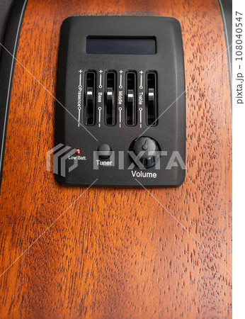 Pickup and tuner of guitar, close up shot, bass, middle and treble zone to tune sound , build on mahogany guitar side wood Pickup and tuner of guitar, close up shot, bass, middle and treble zone to tune sound , build on mahogany guitar side wood 108040547