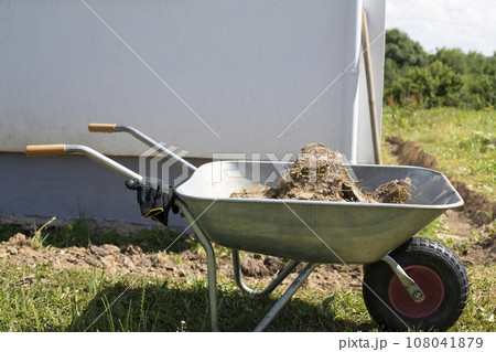 Excavation of earth around the house for the construction of a blind area Excavation of earth around the house for the construction of a blind area 108041879