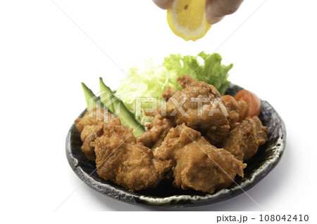 唐揚げにレモンをかける チキン料理の定番 カリカリに揚げた 鶏の唐揚げ 白バック 唐揚げにレモンをかける チキン料理の定番 カリカリに揚げた 鶏の唐揚げ 白バック 108042410