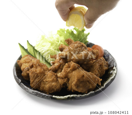 唐揚げにレモンをかける チキン料理の定番 カリカリに揚げた 鶏の唐揚げ 白バック 108042411