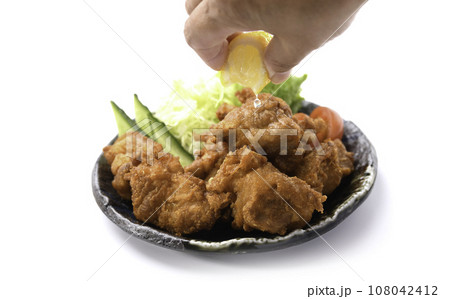 唐揚げにレモンをかける チキン料理の定番 カリカリに揚げた 鶏の唐揚げ 白バック 唐揚げにレモンをかける チキン料理の定番 カリカリに揚げた 鶏の唐揚げ 白バック 108042412