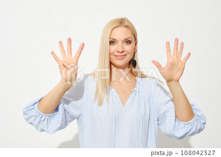 Woman shows nine fingers. Counting with fingers. 108042527