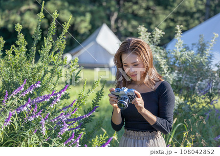 古いフィルムカメラで花を撮影するカメラ女子 108042852