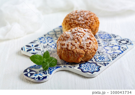 Choux cakes with custard. 108043734