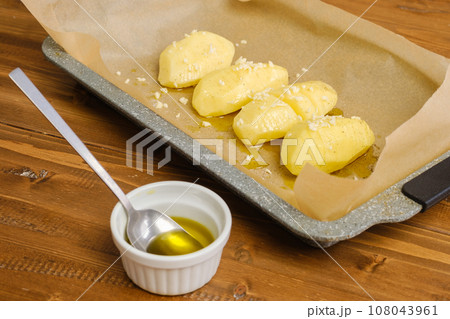 Sliced potato on a parchment in baking tray 108043961