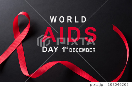 Closeup red ribbon HIV, world AIDS day awareness ribbon on black background. Healthcare and medicine concept. 108046203