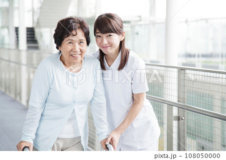 シニアの女性を介護する若い女性の介護士 108050000