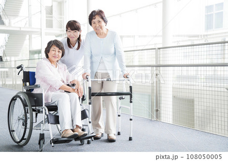 シニアの女性を介護する若い女性の介護士 シニアの女性を介護する若い女性の介護士 108050005