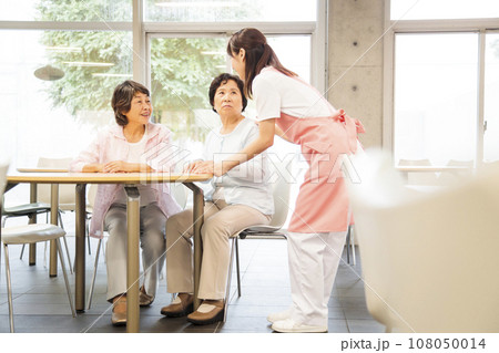 シニアの女性を介護する若い女性の介護士 108050014