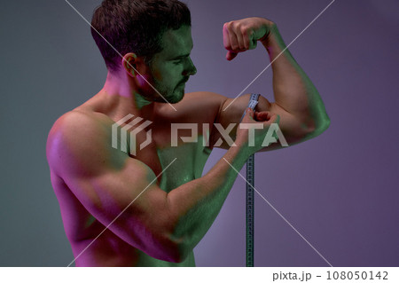 young man is interested interest in the size of their biceps young man is interested interest in the size of their biceps 108050142