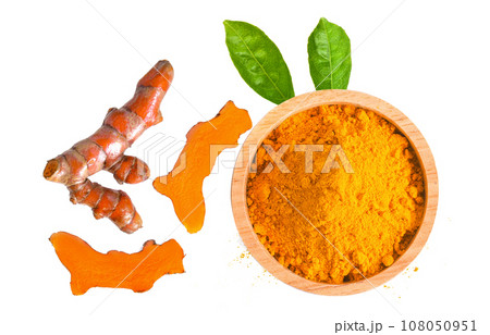curcuma powder in a bowl and root on white background 108050951