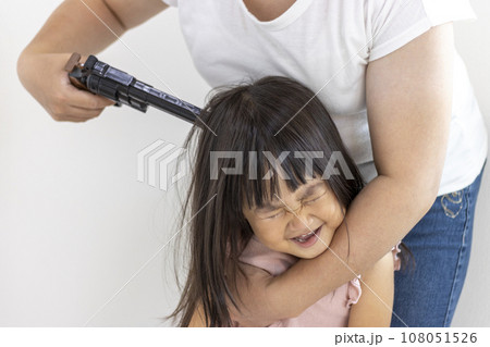 玩具の拳銃を頭に当てられた女の子（3歳、日本人）。人質のイメージ 108051526