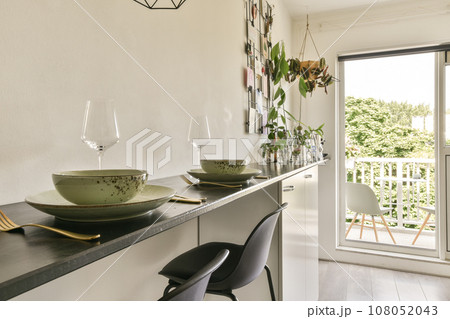 a dining table and chairs in a room with sliding glass doors that open onto the balcony overlooking out to the garden 108052043