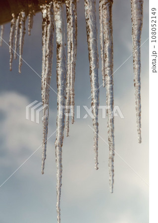 Long icicles of ice on the roof of the house 108052149