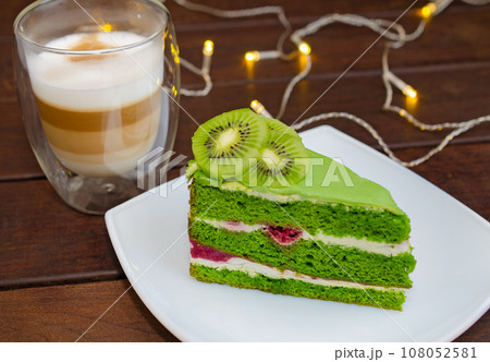 Pistachio cake with kiwi, cream and raspberry filling and Cappuccino coffee 108052581