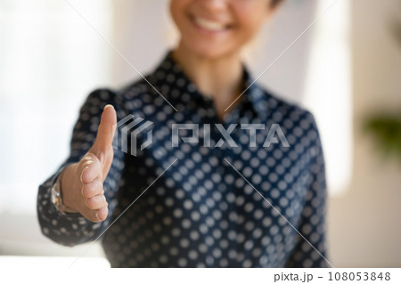 Happy young business woman reaching hand at camera for shaking Happy young business woman reaching hand at camera for shaking 108053848