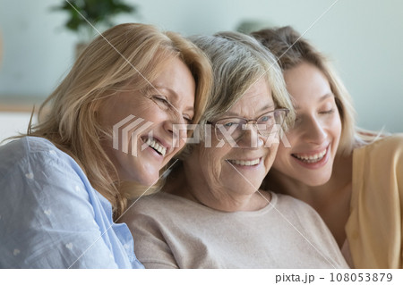 Cheerful ladies of three female generations meeting at home Cheerful ladies of three female generations meeting at home 108053879