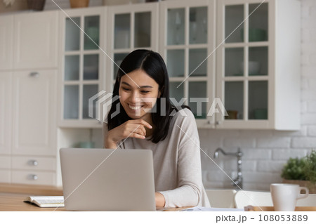 Smiling Asian woman using laptop, studying or working online 108053889