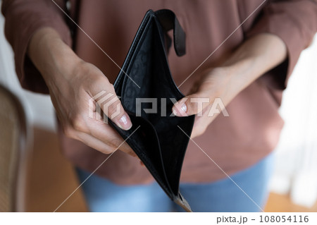 Crop close up Indian woman holding empty wallet in hands Crop close up Indian woman holding empty wallet in hands 108054116