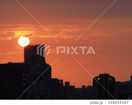 台湾南部高雄市街並日没風景 シルエットの建物、ビル群と茜色の夕空と沈みゆく太陽 台湾南部高雄市街並日没風景 シルエットの建物、ビル群と茜色の夕空と沈みゆく太陽 108054167