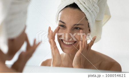 Smiling young woman do facial procedures in bathroom Smiling young woman do facial procedures in bathroom 108054621