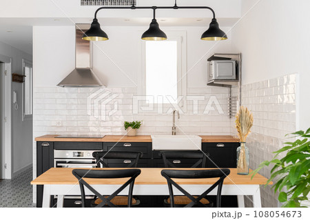 Kitchen unit with appliances and dining table in apartment Kitchen unit with appliances and dining table in apartment 108054673