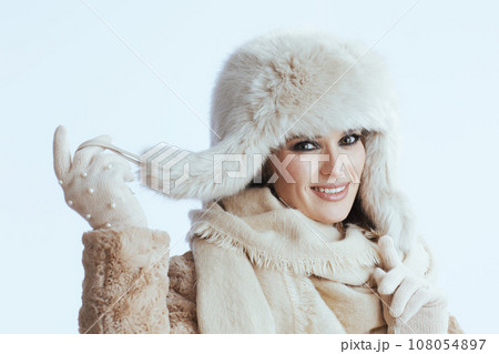 happy stylish woman in winter coat and fur hat on white happy stylish woman in winter coat and fur hat on white 108054897
