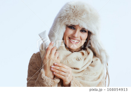 smiling modern woman in winter coat and fur hat on white smiling modern woman in winter coat and fur hat on white 108054913