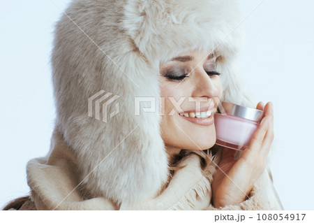 smiling modern woman in winter coat and fur hat on white smiling modern woman in winter coat and fur hat on white 108054917