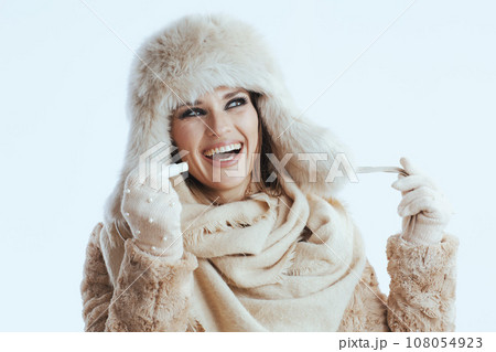 smiling stylish woman in winter coat and fur hat on white smiling stylish woman in winter coat and fur hat on white 108054923