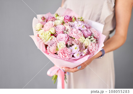 Small Beautiful bouquet of mixed flowers in woman hand. Floral shop concept . Beautiful fresh cut bouquet. Flowers delivery 108055283