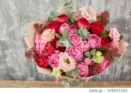 Small Beautiful bouquet of mixed flowers in woman hand. Floral shop concept . Beautiful fresh cut bouquet. Flowers delivery 108055292