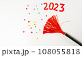 clapperboard with red tassel and confetti and the number 2023 on a white background, new year 108055818