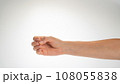 Hand woman gesture fingers clenched into a ring holding a cylindrical object 108055838