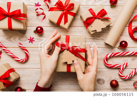 Woman hands holding gift box, preparing surprise for holiday, top view, Christmas and New Year concept 108056115