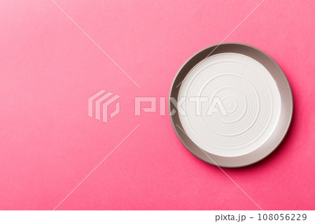 Top view of isolated of colored background empty round white plate for food. Empty dish with space for your design Top view of isolated of colored background empty round white plate for food. Empty dish with space for your design 108056229