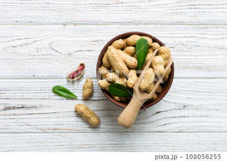 Fresh healthy peanuts in bowl on colored table background. Top view Healthy eating bertholletia concept. Super foods 108056255