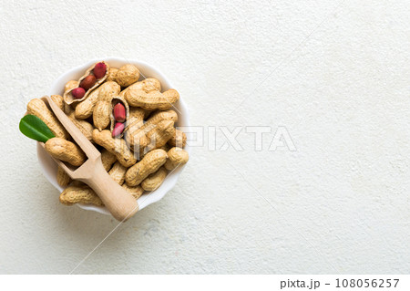 Fresh healthy peanuts in bowl on colored table background. Top view Healthy eating bertholletia concept. Super foods 108056257