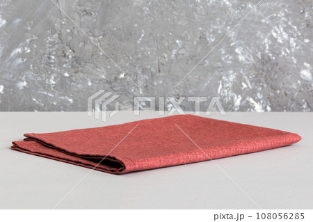 top view with red empty kitchen napkin isolated on table background. Folded cloth for mockup with copy space, Flat lay. Minimal style 108056285