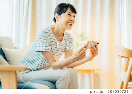 スマホで動画を見る主婦 108056721