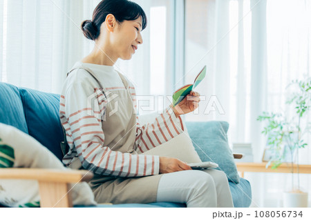 通帳を見る主婦 108056734