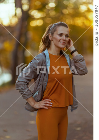 smiling fit woman in fitness clothes in park relaxing 108057947