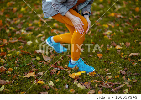 Closeup on woman in fitness clothes in park got leg injury 108057949