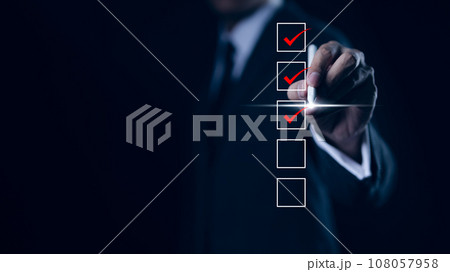 Businessman checking mark on checklist with a red checkmark. online checklist survey, filling out digital form checklist. take an assessment, questionnaire, evaluation, online survey, online exam, 108057958