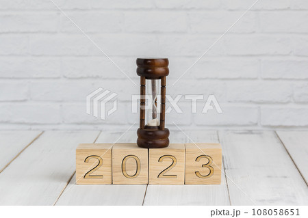 hour glass on 2023 new year block , time concept hour glass on 2023 new year block , time concept 108058651